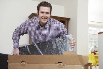 Man Unpacking New Television At Home