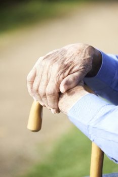 Close Up Of Senior Man’s Hands Resting On Walking Stick