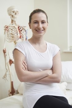 Portrait Of Female Osteopath In Consulting Room