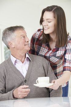 Teenage Granddaughter Bringing Grandfather Hot Drink