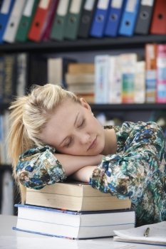 Tired Female Teenage Student Sleeping In Library