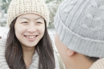 Couple looking at each other in snow
