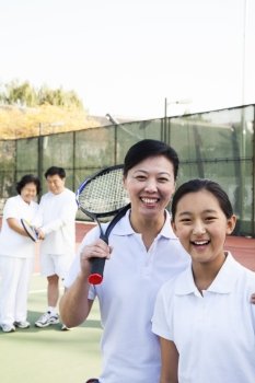 Young girl playing tennis with her coach 