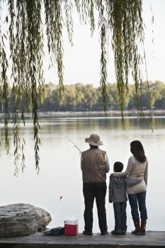 Family fishing off a dock at lake