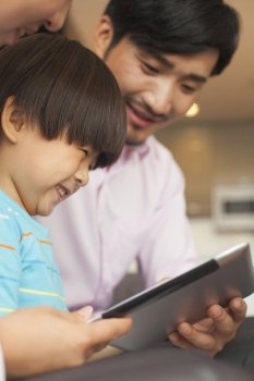 Son and his parents using digital tablet 