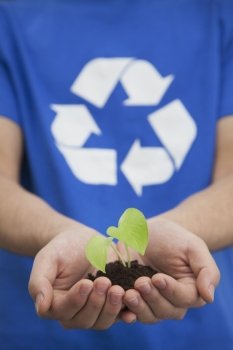 Young Man Holding Seedling in his Hands, Recycling Symbol, Close Up