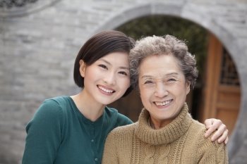 Grandmother and granddaughter in front of round arch, Beijing
