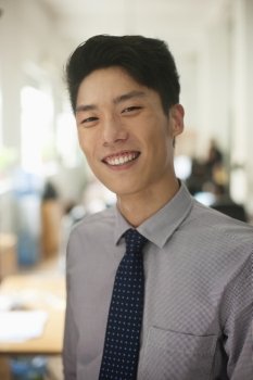 Young man smiling in the office, portrait