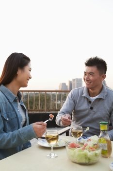 Young couple eating on the roof top