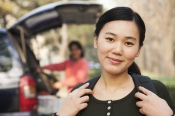 Portrait of girl in front of car on college campus