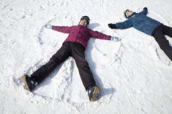 Man and Woman Lying on the Snow Making Snow Angel