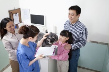 Family with pet dog in veterinarian’s office