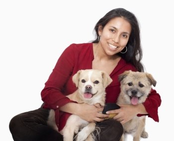 Portrait of woman embracing her dogs, studio shot
