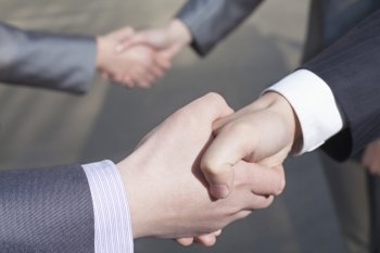  Close up of four business people shaking hands