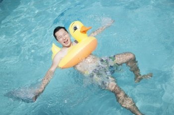 Man wearing a yellow duck inflatable tube and playing in the pool