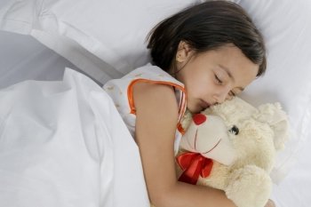 Girl sleeping with her teddy bear 
