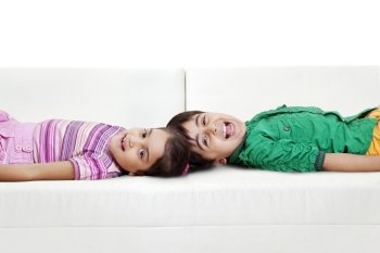 Brother and sister lying on sofa 