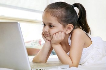 Little girl looking at a laptop 