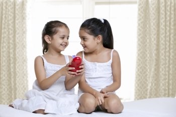 Smiling girls playing with a toy 
