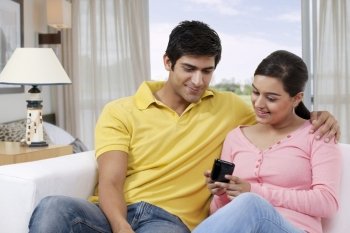 Young couple looking at mobile phone together 