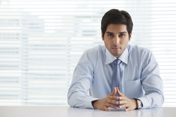 Portrait of handsome young businessman sitting in office 