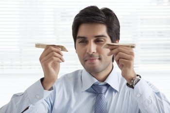 Close-up of handsome businessman playing with paper airplanes 
