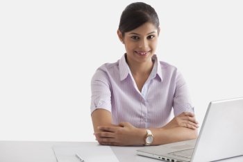 Portrait if young businesswoman sitting at desk with laptop 
