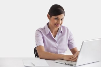 Portrait of female executive working on laptop 