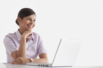 Smiling businesswoman with laptop looking away 
