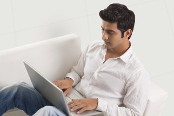 Relaxed young man working on laptop 