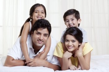 Smiling family lying on bed 
