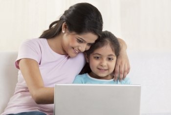 Mother and daughter using laptop together 