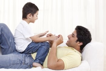 Boy sitting on father at home 