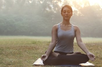 Young woman meditating in park 
