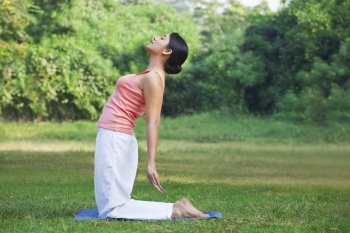 Young woman doing yoga in park 