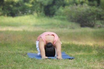 Woman practicing yoga in lawn 