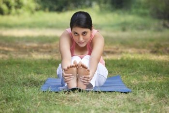 An attractive woman stretching in lawn 