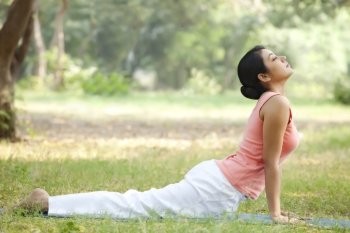 Woman doing yoga in lawn 