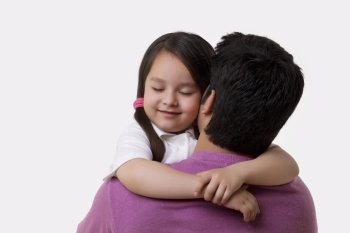 Father and daughter embracing over white background 