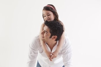 Girl sitting on her father’s back 