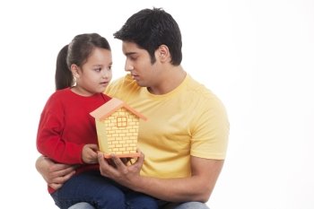 Little girl and man holding dollhouse 
