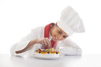 Female chef making mixed fruit cake isolated over white background 