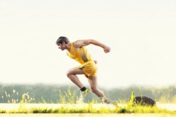 Profile shot of young male runner running outdoors