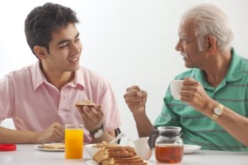 Grandfather and grandson eating breakfast