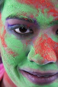 Woman’s face covered in holi colours 