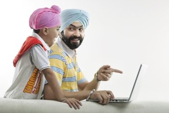 Father showing something on his laptop to his son 