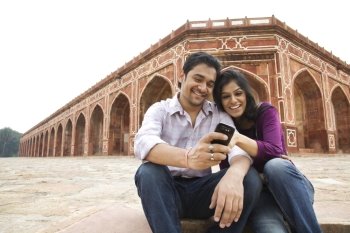 Couple reading an sms at Humayuns Tomb 