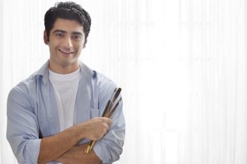 Smiling male painter holding paintbrush 