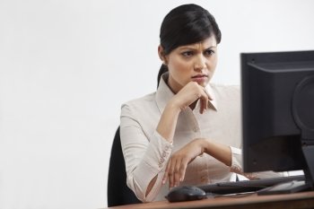 Young businesswoman looking at computer with full concentration 