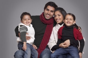 Portrait of smiling family over grey background 